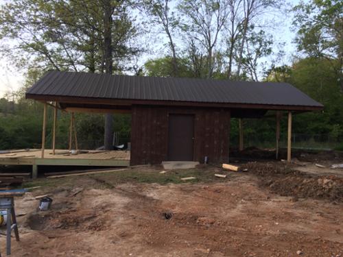 The venue building with a new roof and deck, after wrapping the block building in stained sawmill lumber. 
